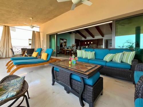 un soggiorno con un divano blu e un tavolo di Luxury Oceanfront Penthouse Concierge Cook a Punta Mita