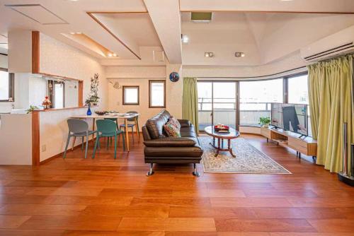a living room with a couch and a table at 台東区広々吹き抜けリビングのメゾネットタイプのお家 in Tokyo
