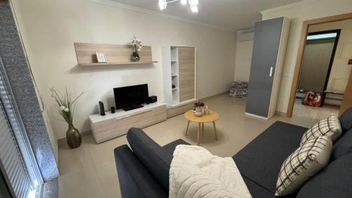 un salon avec un canapé et une télévision dans l'établissement Laguna mar beach house, à Monte Gordo