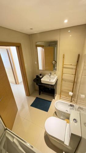 a bathroom with a toilet and a sink at Laguna mar beach house in Monte Gordo
