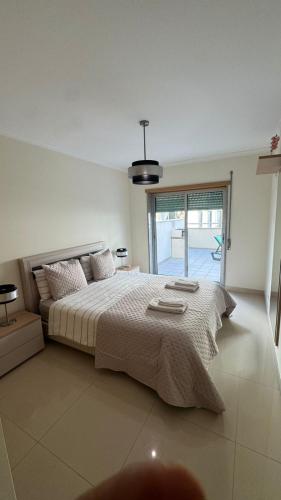 a bedroom with a large bed and a large window at Laguna mar beach house in Monte Gordo
