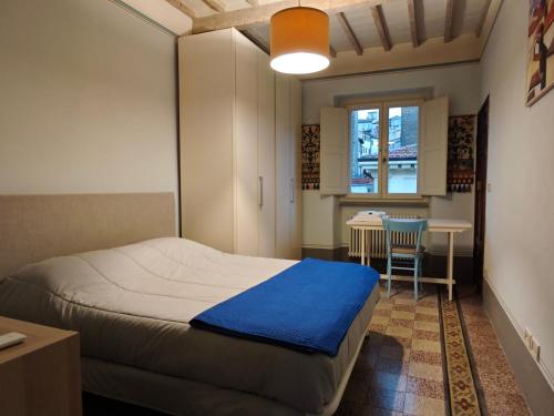 a bedroom with a bed and a table and a window at Garibaldi 23 in Arezzo