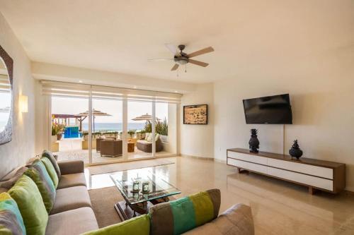 a living room with a couch and a tv at Luxury Oceanfront Condo Infinity Pool in Punta Mita