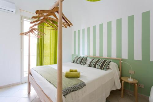 1 dormitorio con 1 cama con rayas verdes y blancas en Le Scale Apartment, en Palermo