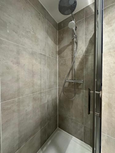 um chuveiro com porta de vidro em um banheiro em Hotel Azur em Lyon
