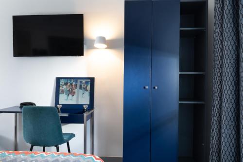 una habitación con un escritorio y un armario azul en Palym, en París