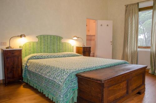 Schlafzimmer mit einem Bett mit grüner Tagesdecke in der Unterkunft Casale Cipresso in Migliarino