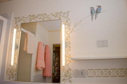 ein Badezimmer mit einem Spiegel und rosa Handtüchern an der Wand in der Unterkunft Casale Cipresso in Migliarino