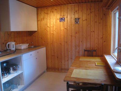 una cucina con tavolo e parete in legno di Kråkeskogsgården, nature in town a Osby