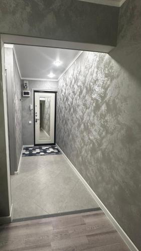 un pasillo con una puerta y una pared con pinturas en Люкс 2х комнатная квартира, en Taraz