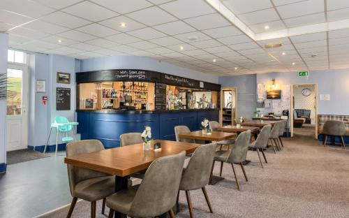 un restaurante con mesas y sillas y un bar en Seacote Hotel, en St Bees