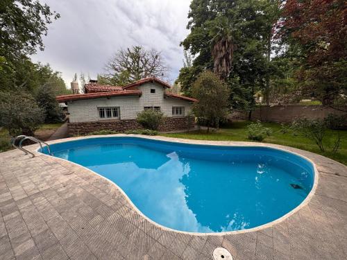 卢汉德库约LA CASONA DE LU的房子前面的一个蓝色大游泳池