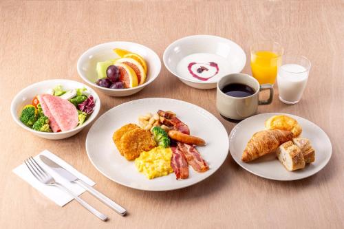 een tafel met borden vol ontbijtproducten en drankjes bij Richmond Hotel Asakusa in Tokyo