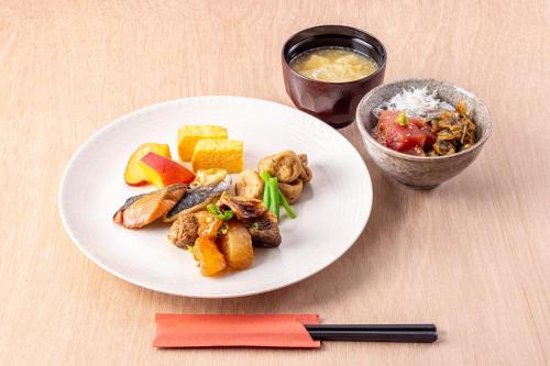 een wit bord eten op een houten tafel bij Richmond Hotel Asakusa in Tokyo