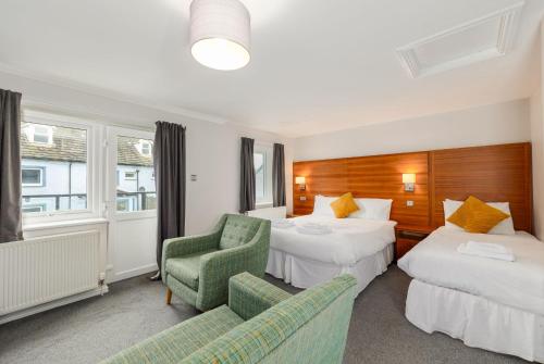 una habitación de hotel con dos camas y una silla en Seacote Hotel, en St Bees