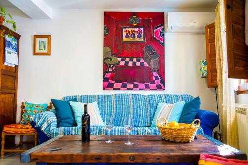 a living room with a blue couch and a table at Vilamurada • Terraza con vistas al casco antiguo in Denia