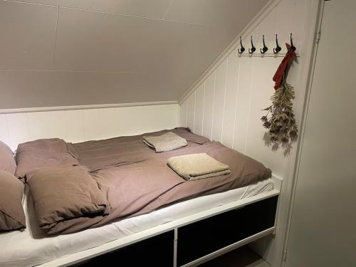 a bed with two pillows on it in a room at Stylish toppleilighet med flott utsikt - sentralt in Vossevangen