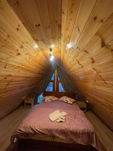 a bedroom with a bed in a wooden ceiling at Cabana A frame Casa Edy in Călimăneşti