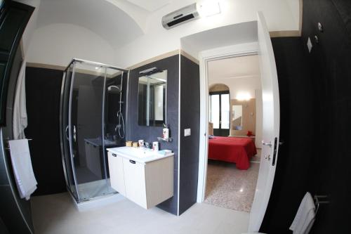 a bathroom with a sink and a shower and a mirror at RTA Palazzo Judica in Palazzolo Acreide