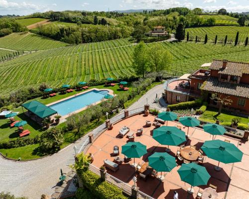 an aerial view of a resort with a pool and umbrellas at Poggio al Casone in Crespina