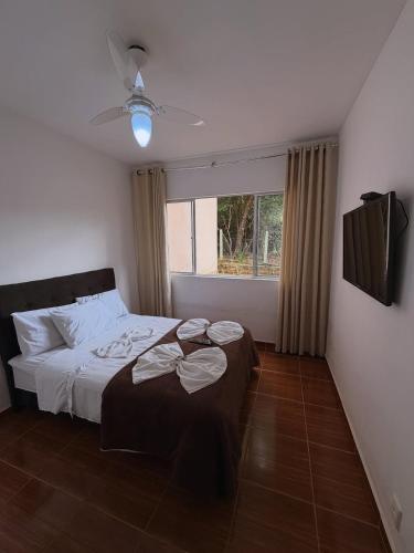 ein Schlafzimmer mit einem Bett und einem Fenster in der Unterkunft Pousada Rio Cipó in Serra do Cipo