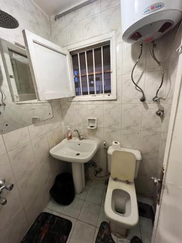 a small bathroom with a toilet and a sink at Aisha guesthouse in Aswan