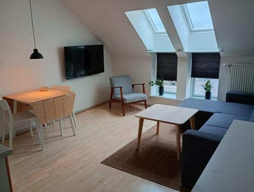 a living room with a blue couch and a table at Apartment in the heart of Herning in Herning
