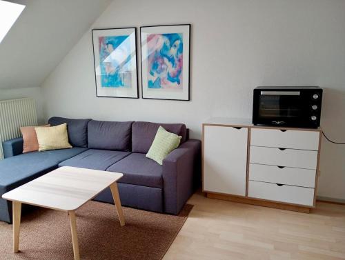 a living room with a blue couch and a tv at Apartment in the heart of Herning in Herning