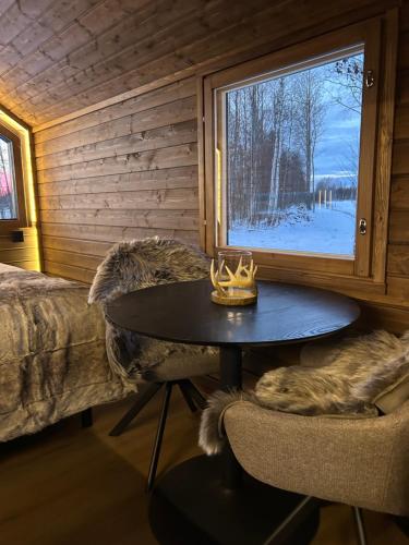 a room with a table and a window in a cabin at Arctic circle cabin 1 in Rovaniemi
