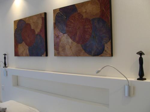 two paintings of flowers on a wall with a lamp at Hôtel Poste et Champanne in Brioude