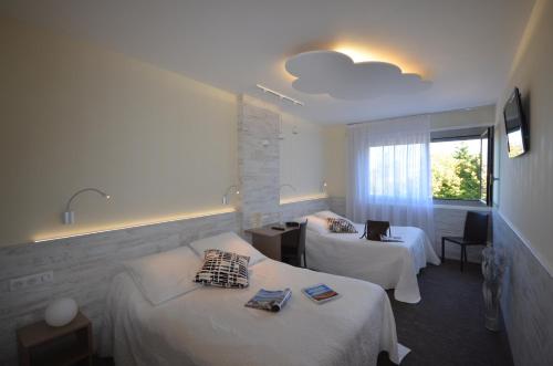 um quarto de hotel com duas camas e uma janela em Hôtel Poste et Champanne em Brioude
