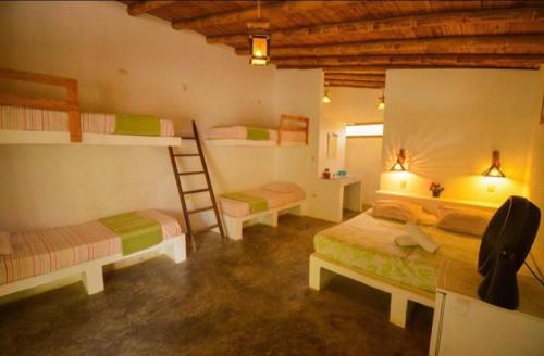 una camera con due letti a castello e una scala di Bali Lodge Máncora - Playa, Piscina & Desayuno a Máncora