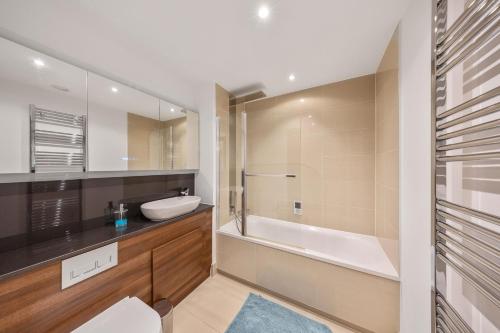 a bathroom with a tub and a sink and a toilet at Stylish long & short stay flat with parking & Wifi sleeps 5 in Maidstone
