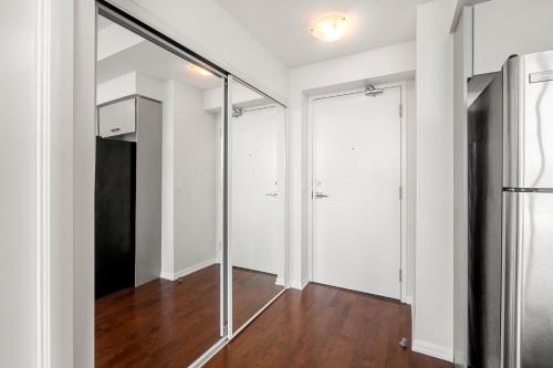 an empty room with sliding glass doors and wood floors at 1 Bedroom Condo Burano Downtown Toronto in Toronto