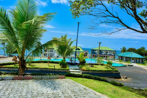 a resort with a pool and palm trees at Milo & Aby Resort, Le Mar in Kribi