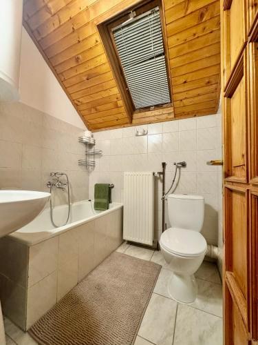 a bathroom with a toilet and a tub and a sink at Kovács Vendégház in Harkány