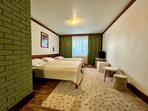 a bedroom with two beds and a brick wall at Vila Romanitza in Dărmăneşti