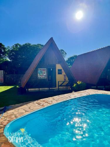 a house with a swimming pool in front of it at Chalés Dinhá-Pousada Recanto do Rapa in Brumadinho