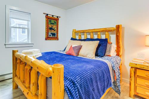 SunapeeLakefront Cabin with Panoramic Water View and Access的一间卧室配有一张带蓝色棉被的木床