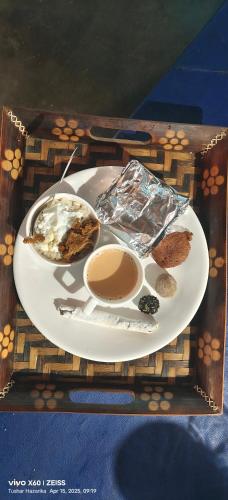 un plato de comida en una bandeja de madera en Kaziranga Tea Nest Homestay, en Kāziranga