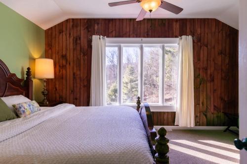 Un dormitorio con una cama y una ventana grande. en A Parkway Cabin, en Boone