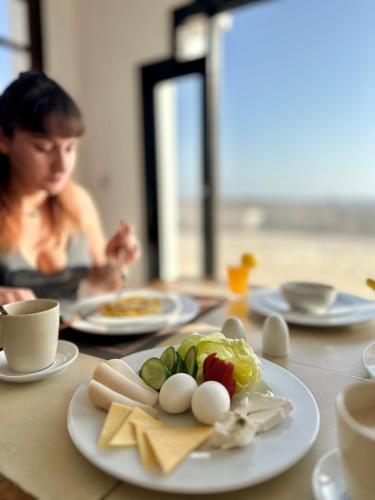a woman sitting at a table with a plate of food at Daniela Diving Resort Dahab in Dahab
