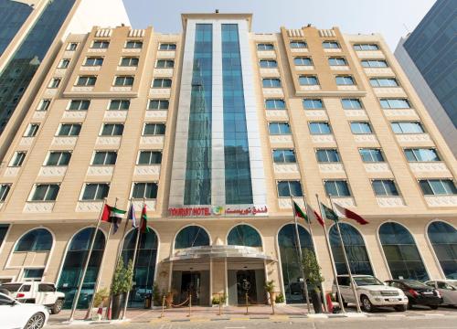 a building with flags in front of it at Tourist Hotel in Doha
