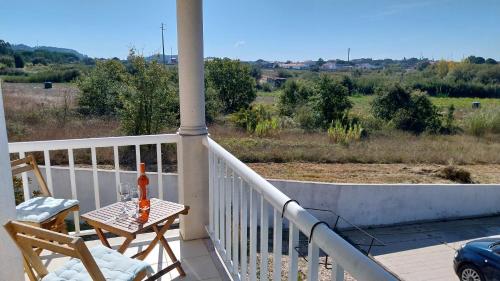 a bottle of alcohol sitting on a table on a balcony at Casa da Alegria Boutique Guest Suite in Caldas da Rainha