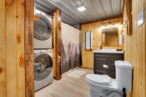 a bathroom with a toilet and a washer and dryer at The Elk Camp in Benezette