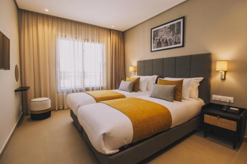 a bedroom with a large bed with a large window at Dally Apart Hotel in Rabat