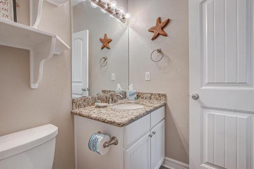 ein Badezimmer mit Waschbecken und Spiegel in der Unterkunft Crystal Moon in Crystal Beach