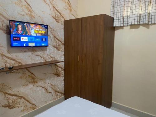 Zimmer mit einem TV an einer Steinmauer in der Unterkunft Résidence Keur Mame Seye 3 in Dakar