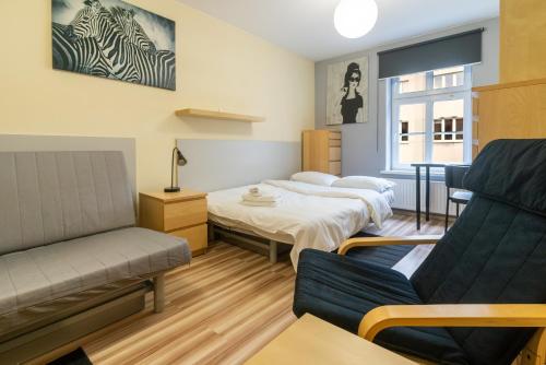 a room with two beds and a couch at Katowice Central Apartment by BookingHost in Katowice