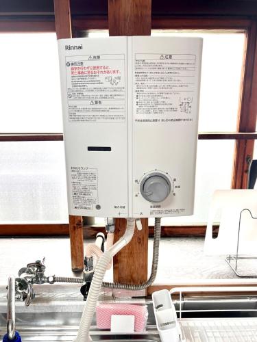 a computer monitor sitting on top of a kitchen counter at 2025年12月OPEN! 豊橋民泊 最大13名様 駐車場2台無料 駅徒歩7分 Traditional Japanese house ,Toyohashi Aichi in Toyohashi